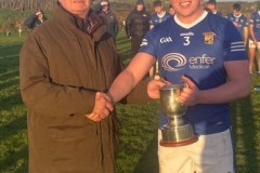 Chairman Myles Barry presenting the JBHL Trophy to  Ballinhassig Captain Dara Cullinane