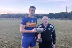 Carrigaline Captain Ryan Delaney presented with the U21 A Football Championship Trophy by Vice-Chair Kevin O'Donovan