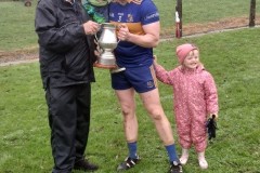 Chairman Myles Barry presenting the Pad Joe Cronin Cup to  Carrigaline  Captain Ian Sheeran & co. following their victory in the Procure.ie SE JAFC Final.