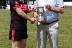 Crosshaven  Captain Daniel Dransfield being presented with Junior B Hurling League cup by Myles Barry