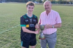 Chairman Myles Barry presenting the U21 B Football Championship trophy to Diarmuid Ó'Murchú's Captain Fionn Mansfield